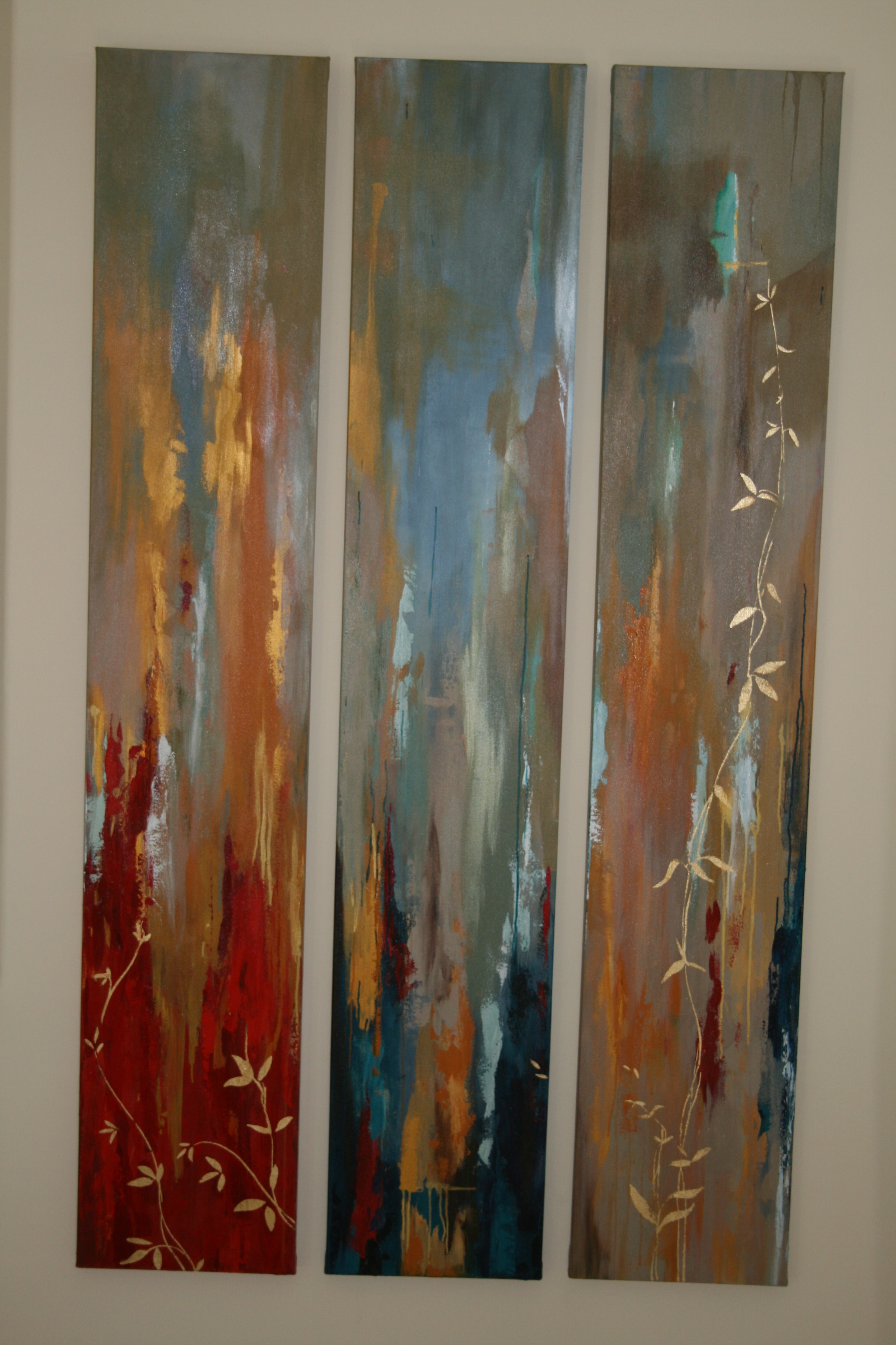 Abstract triptych in earth tones, blues, reds and gold leaf with trailing vine motifs — commissioned artwork by Lisa Autry