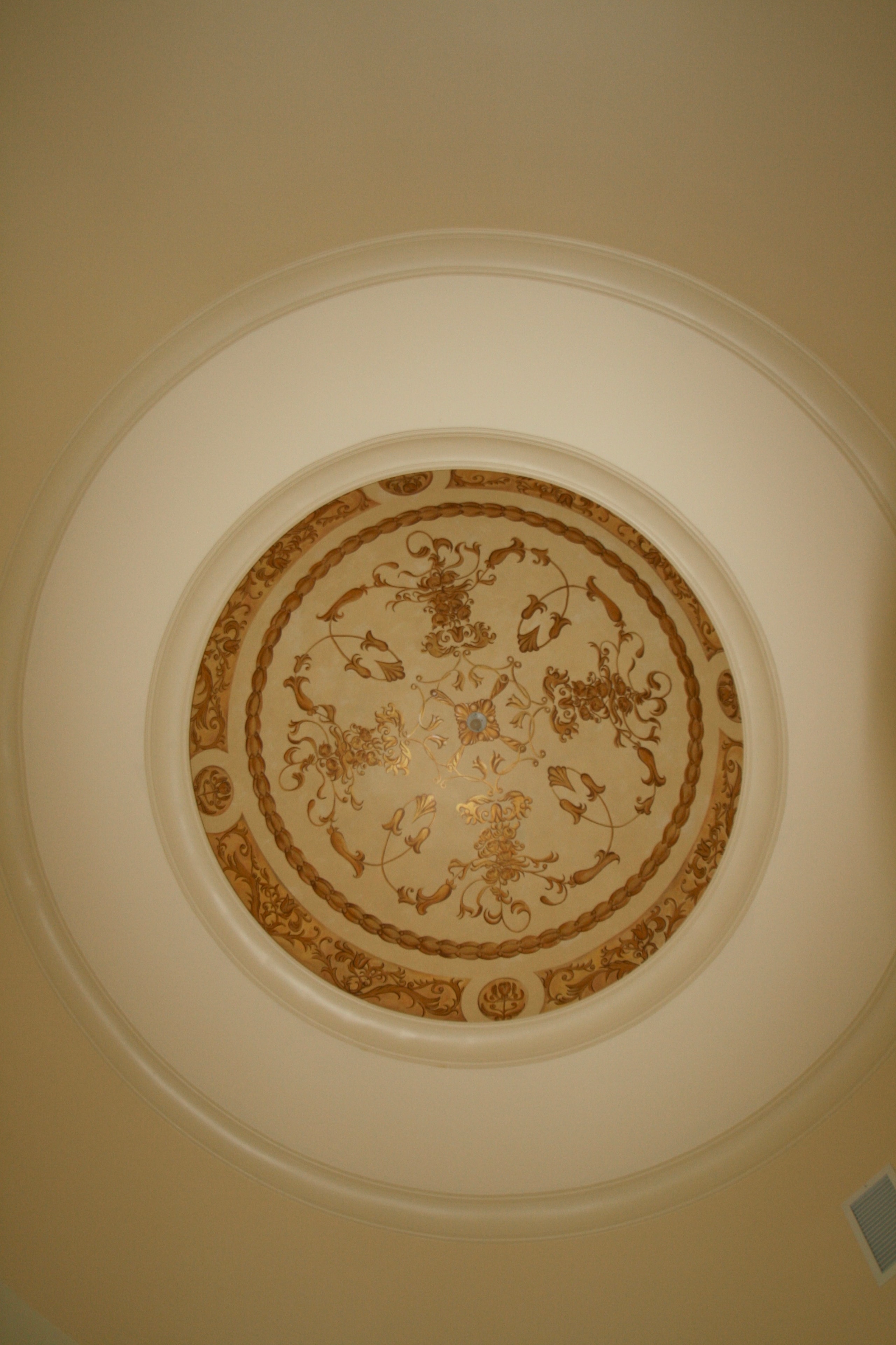 Ornate ceiling medallion with gold stencil scrollwork in circular dome