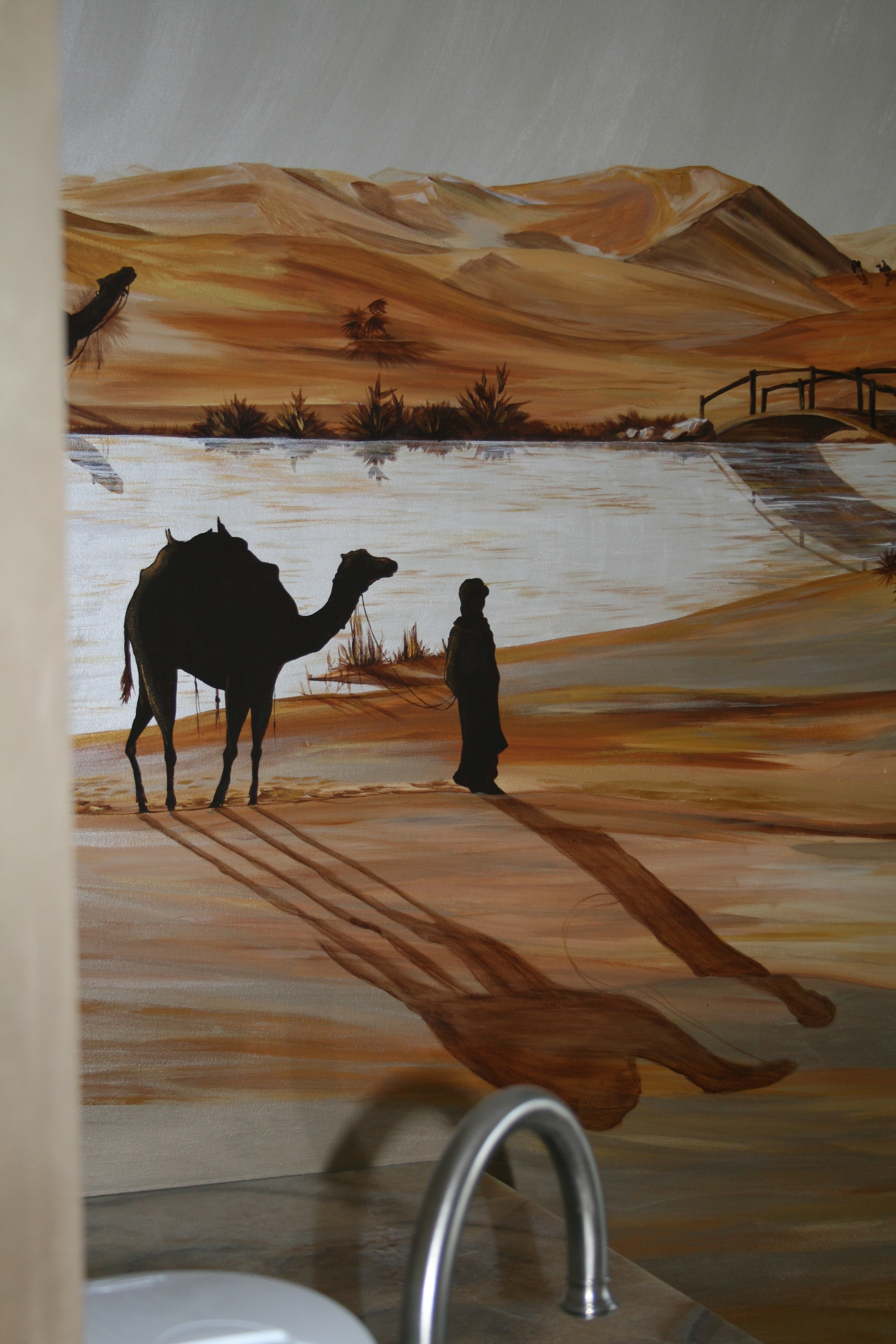 Sahara desert mural — camel and figure silhouette by oasis with long shadows