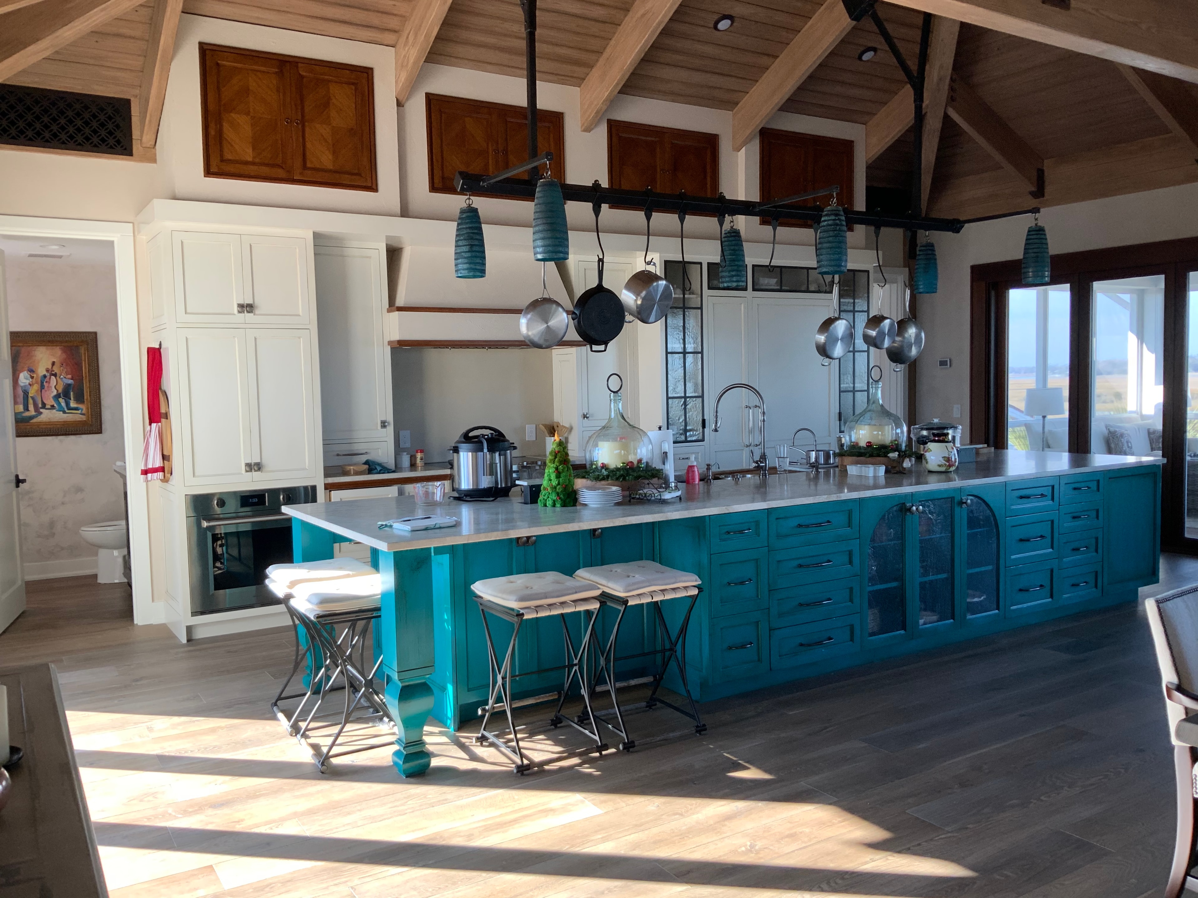 Figure Eight Island — teal kitchen island with timber ceiling and hanging cookware