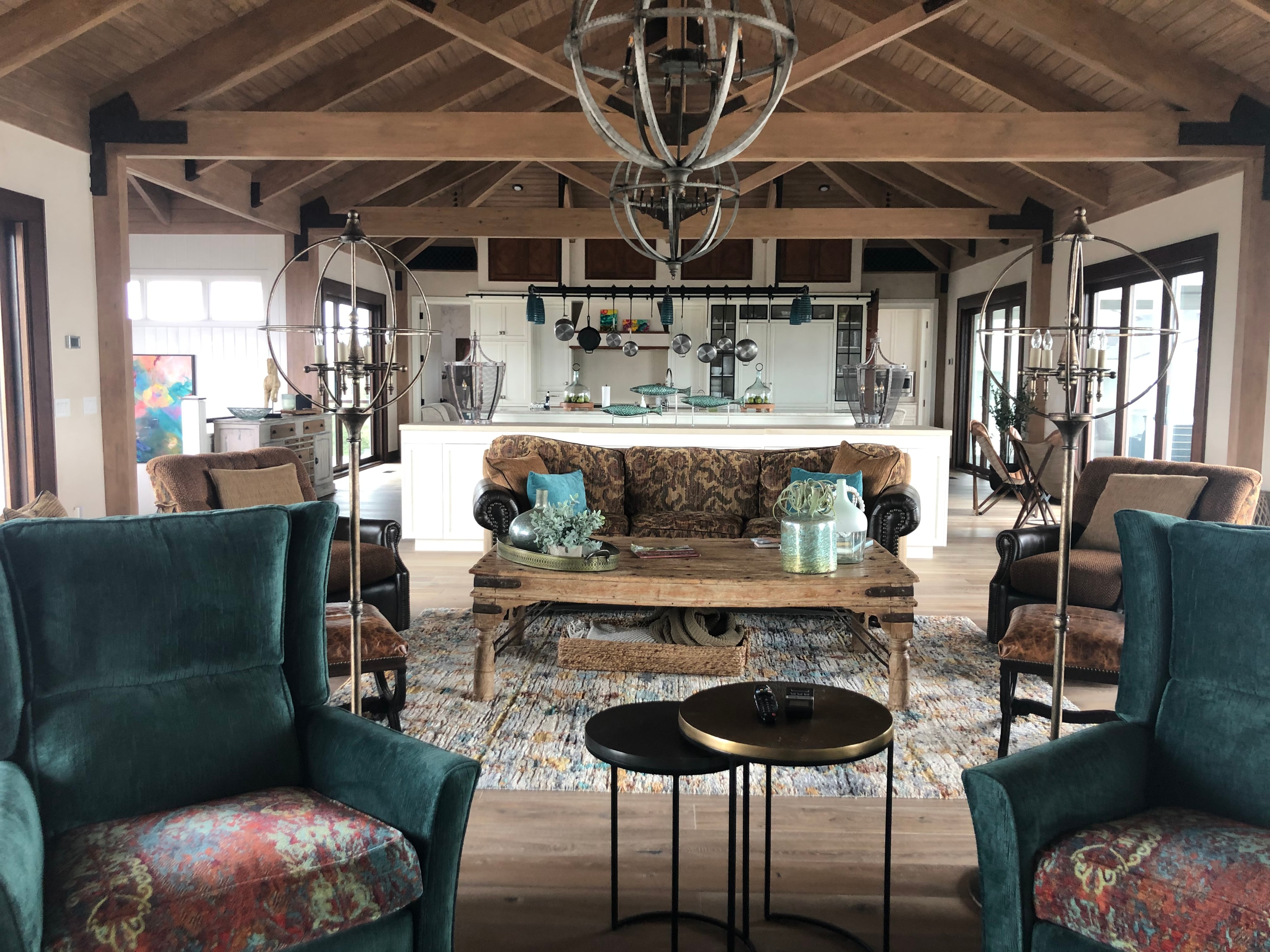 Figure Eight Island — open-plan living room with teal wingback chairs and timber ceiling