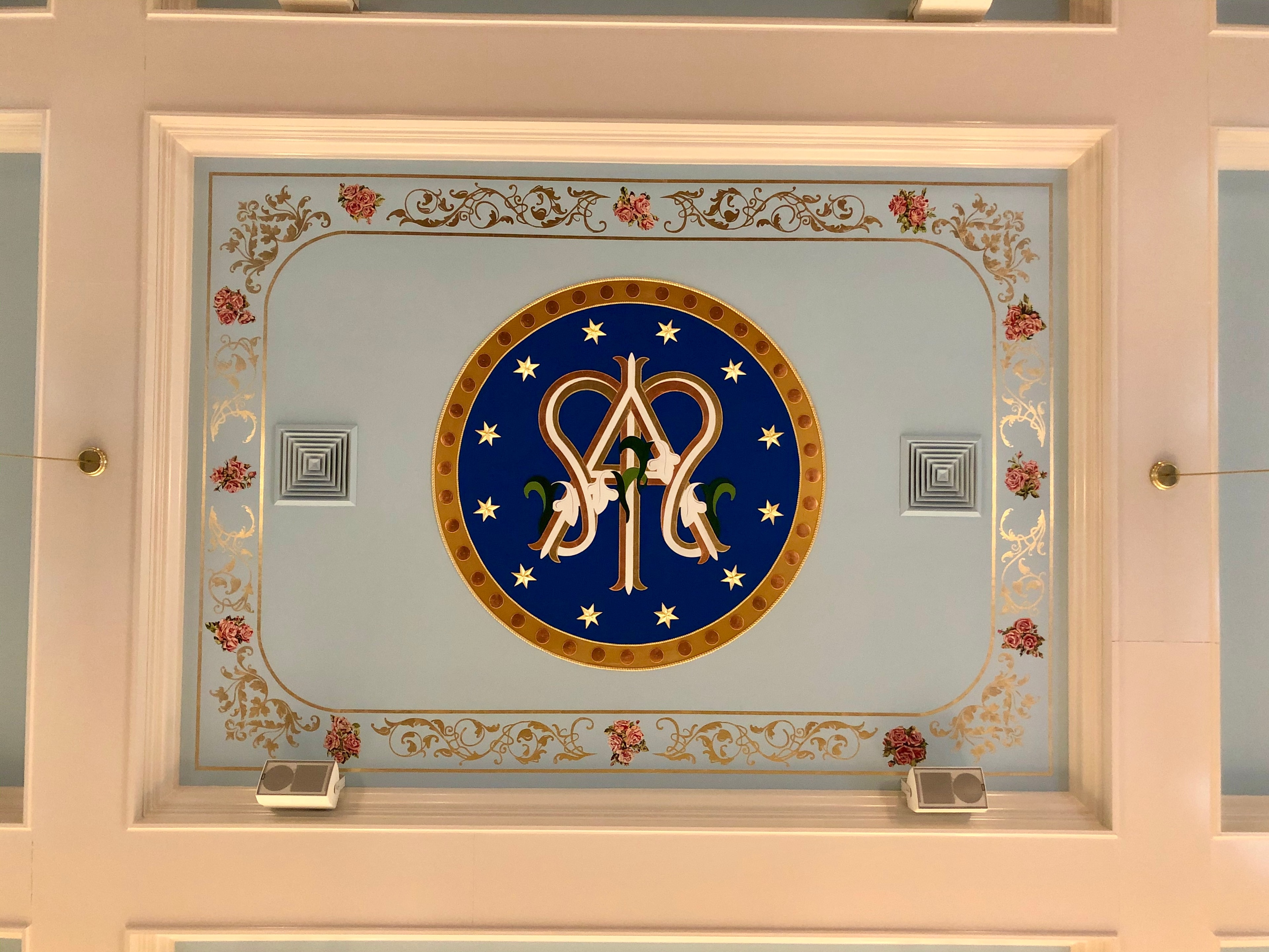 Ornate ceiling medallion with monogram design at St. Ann Catholic Church