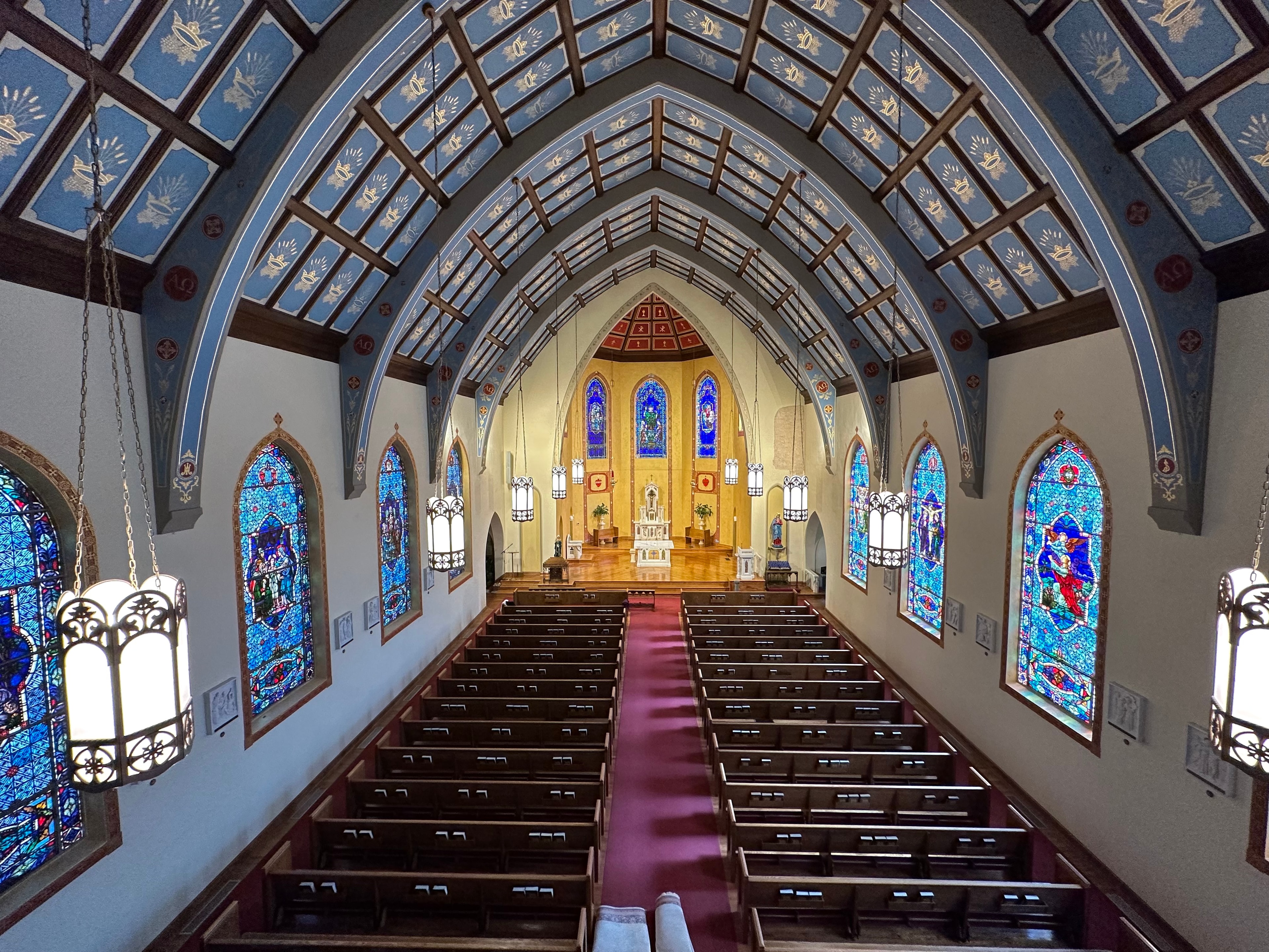 Full nave of St. Patrick Cathedral with blue painted ceiling and stained glass