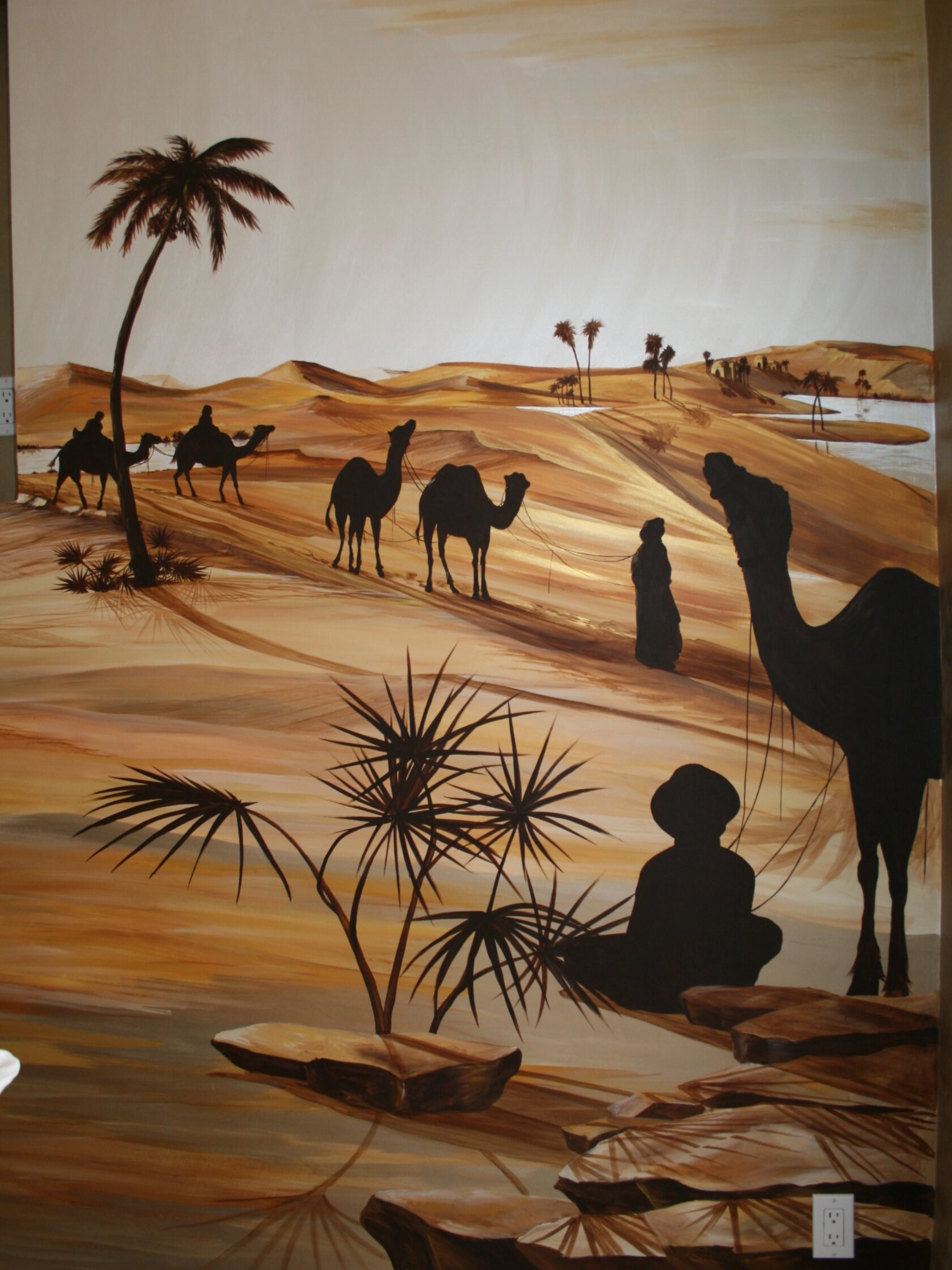 A painting of people and camels in the desert.