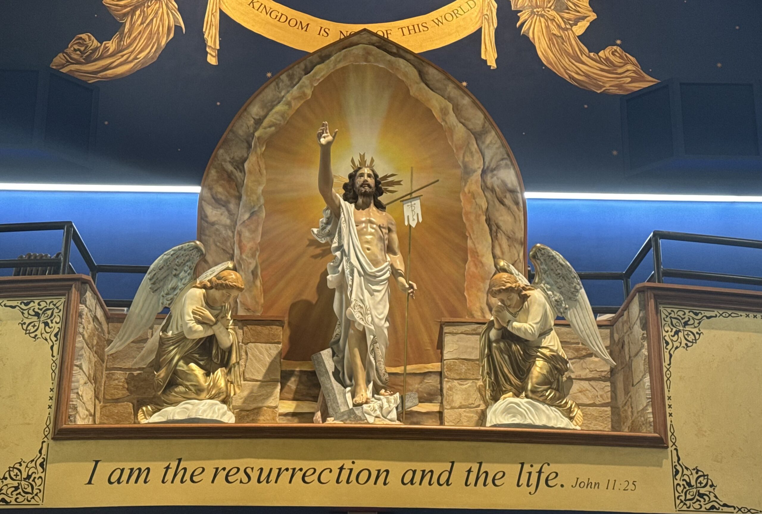 A statue of jesus is shown in front of two angels.