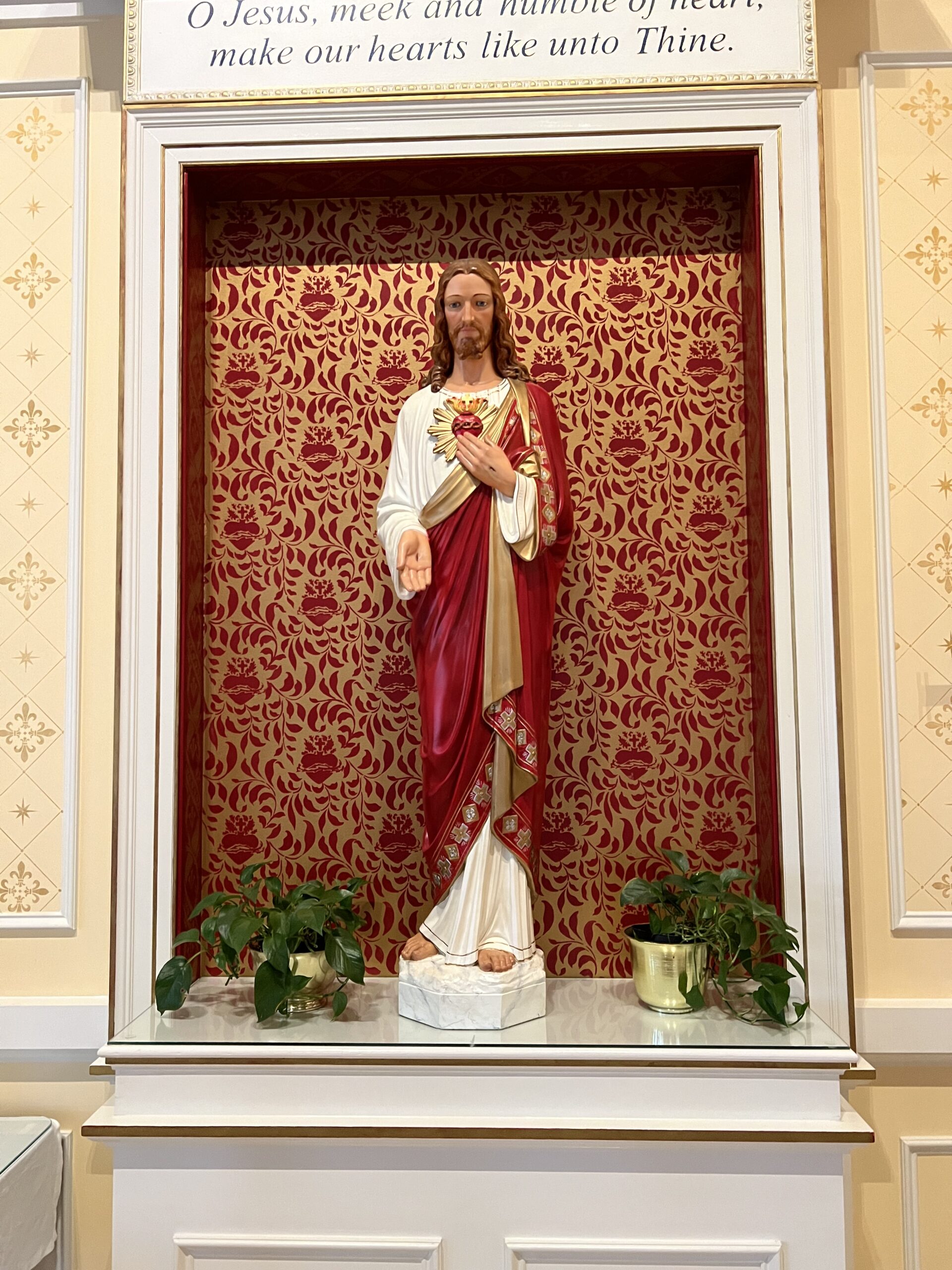 A statue of jesus is in the center of a room.