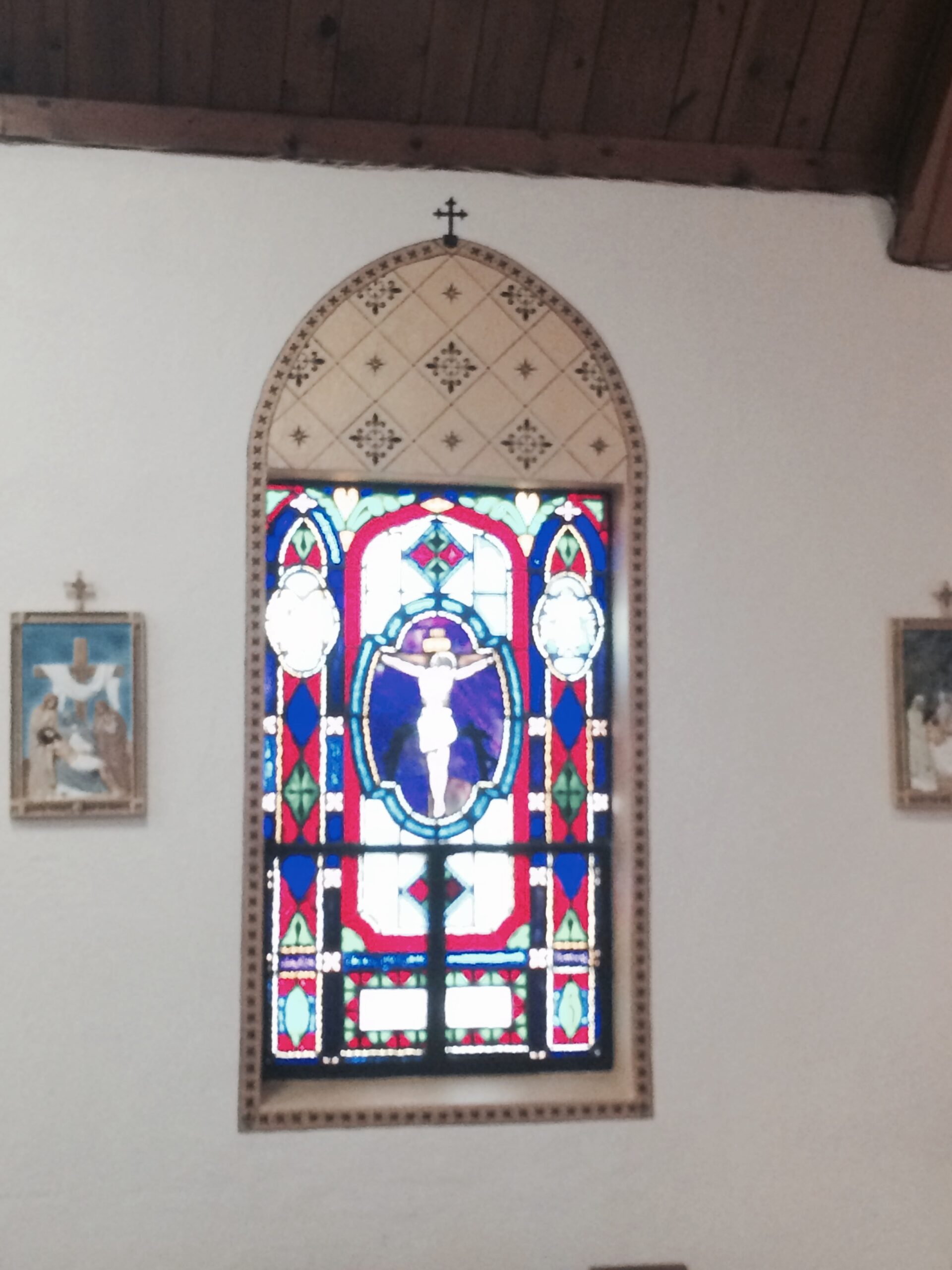 A stained glass window in the center of a church.