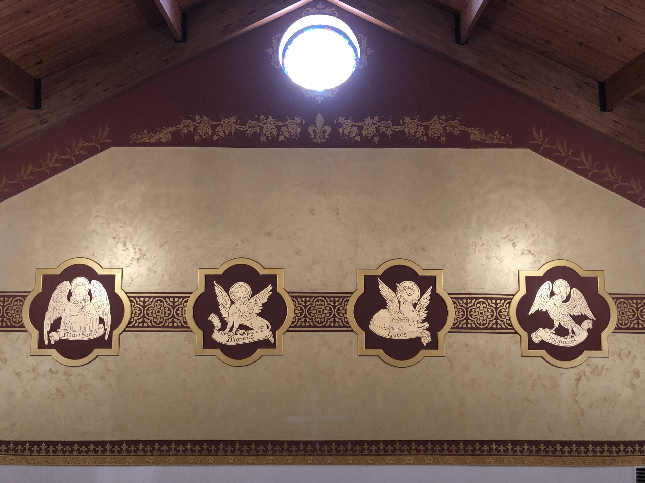 A wall with four angels on it and a light