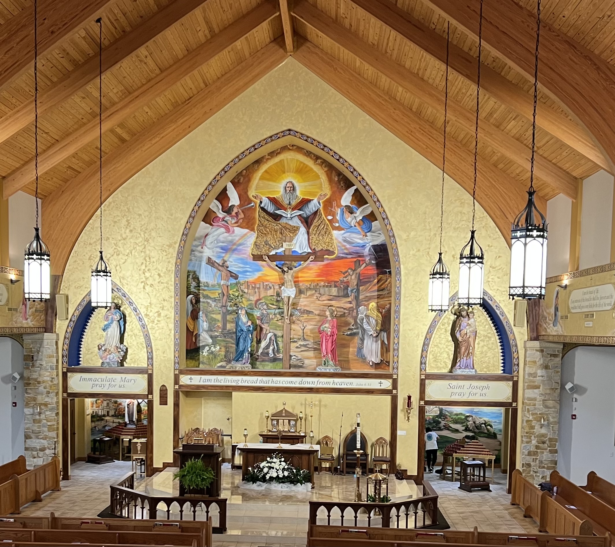 A church with stained glass windows and paintings on the walls.