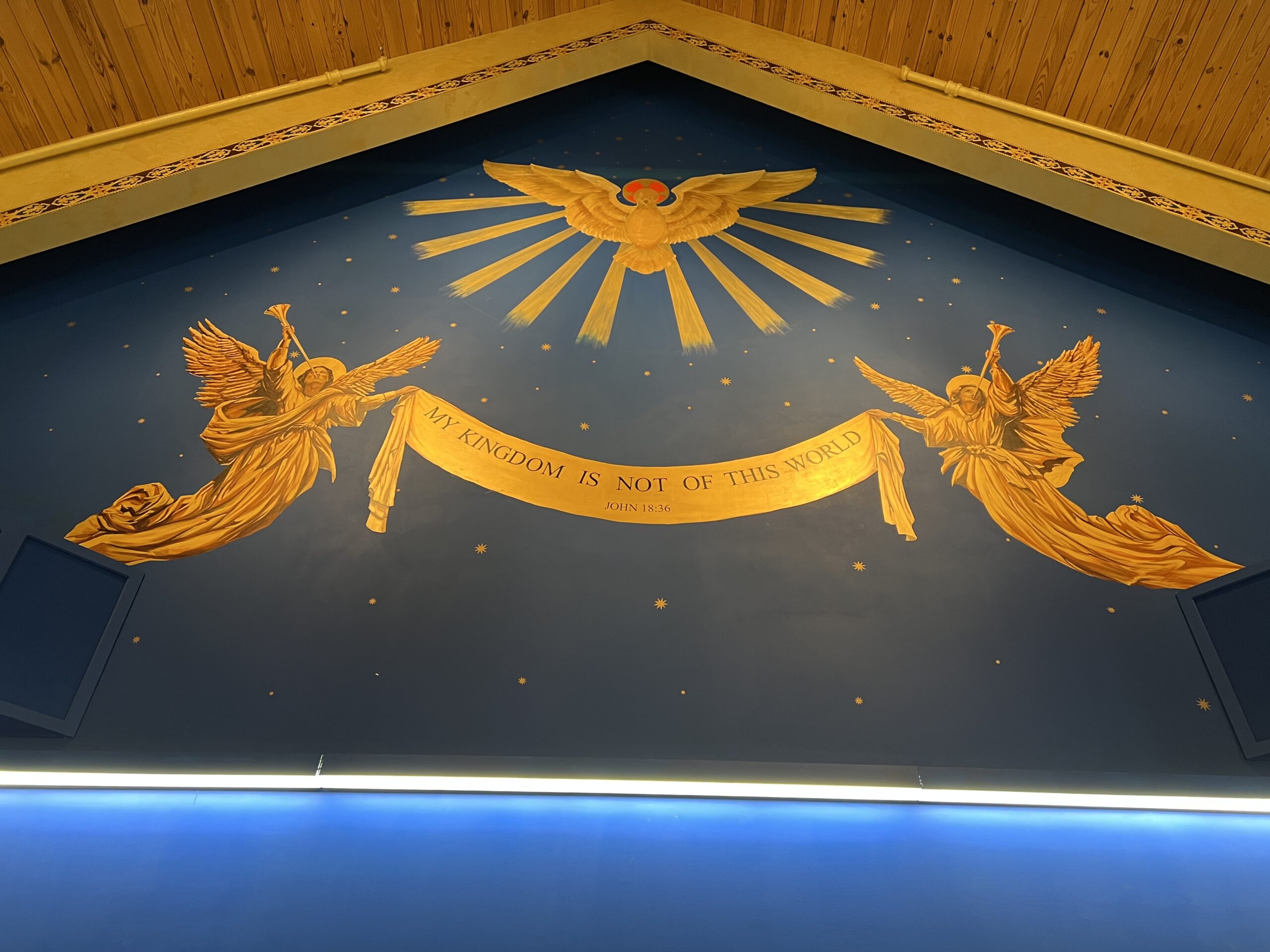 A ceiling with angels and sun rays painted on it.