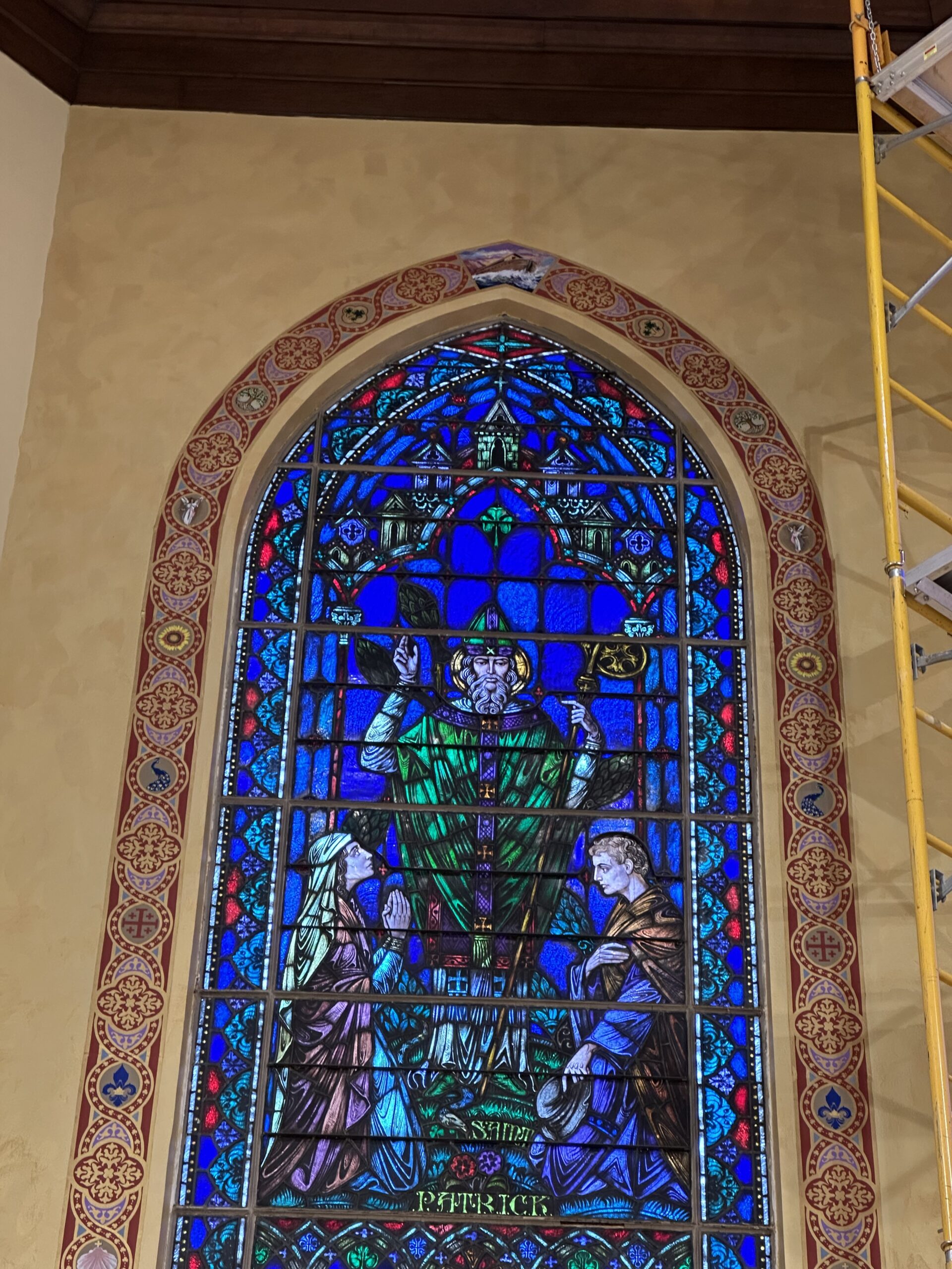 A stained glass window with a man in the center of it.