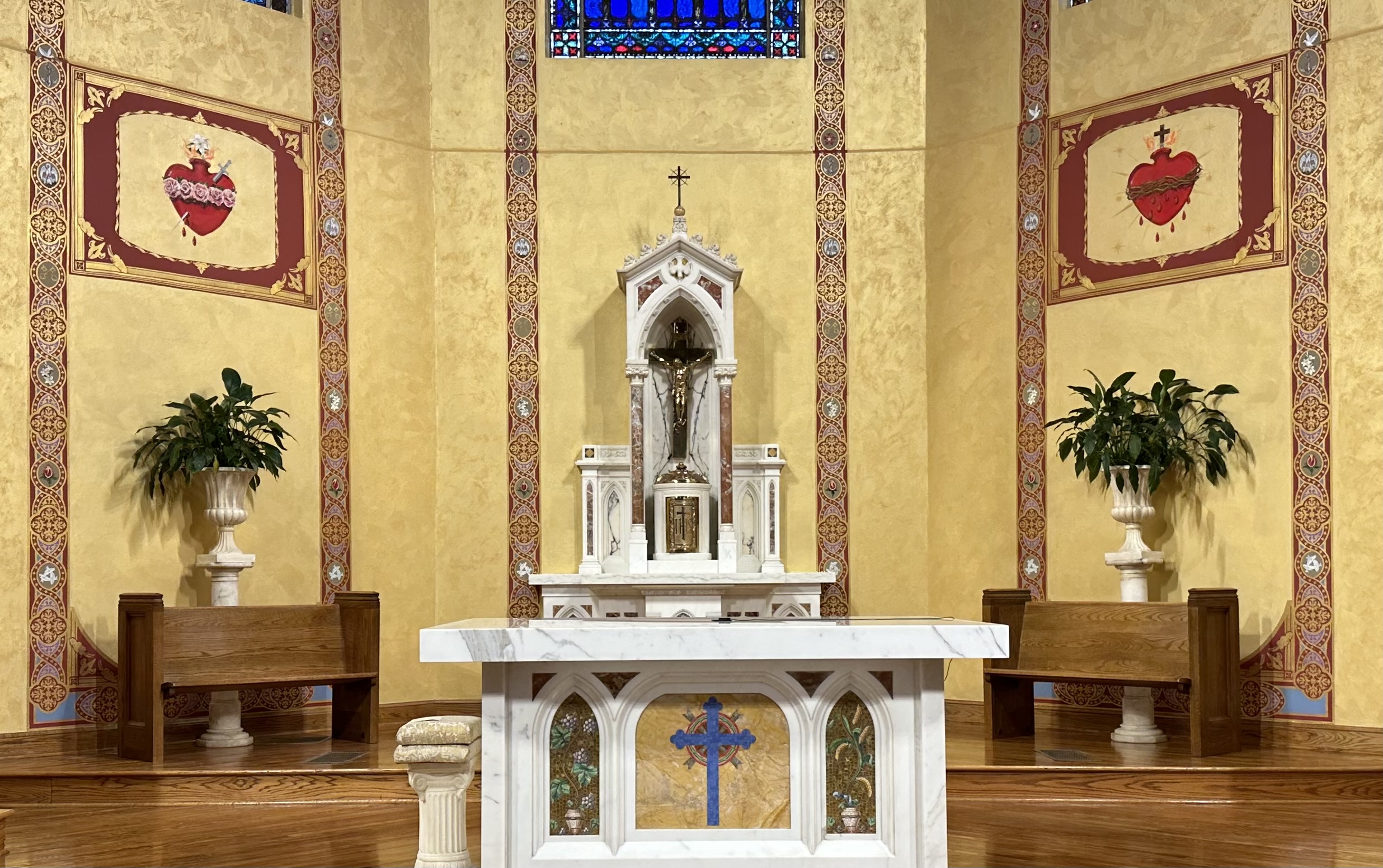 A church with a large altar and cross on the wall.