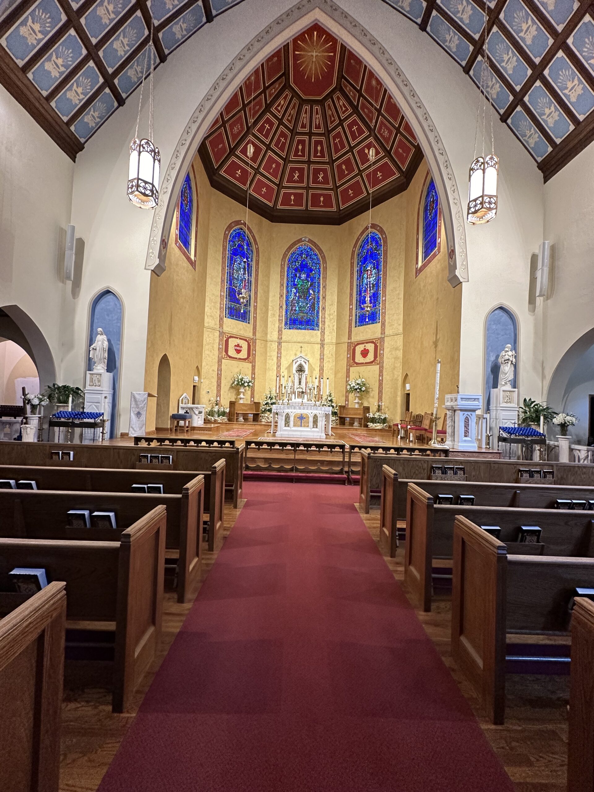 A church with pews and chairs in front of the altar.