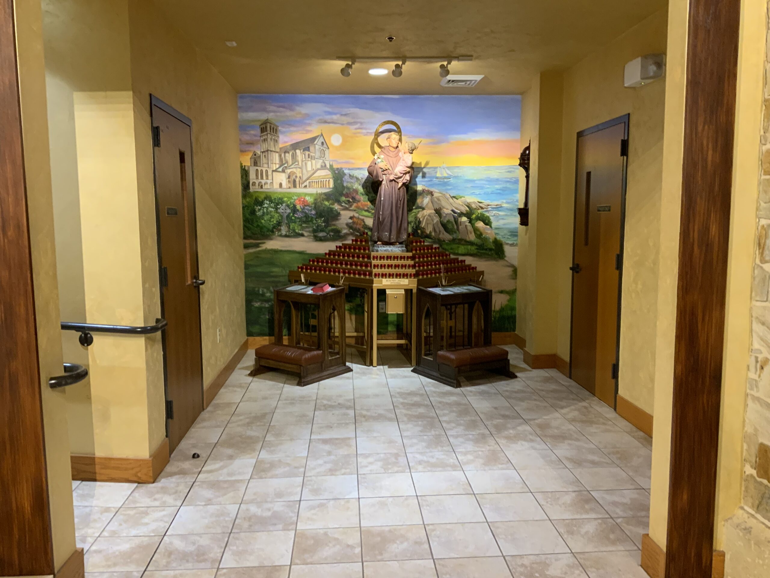 A hallway with two chairs and a painting on the wall.