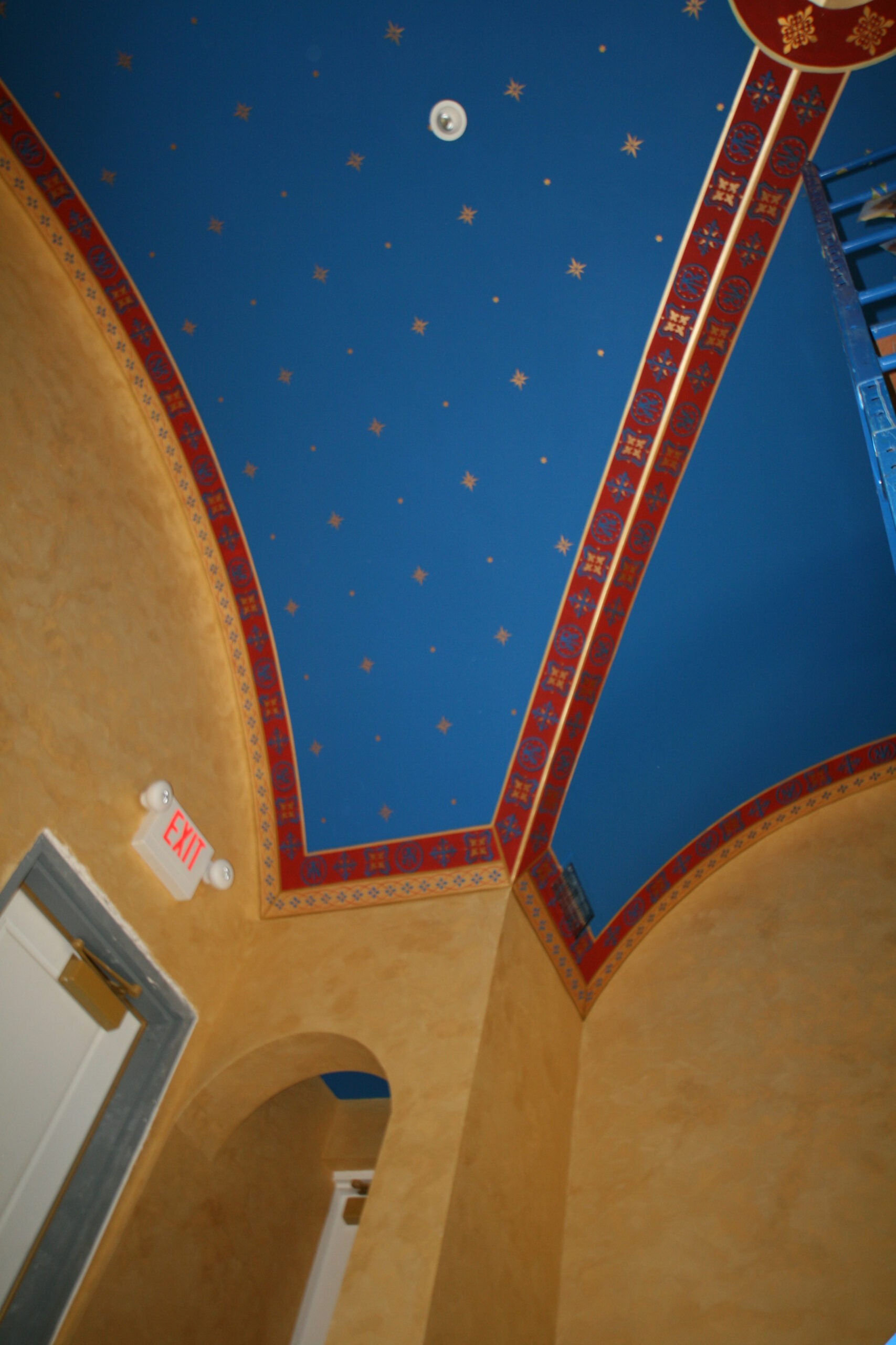 A blue ceiling with red and yellow designs on it.