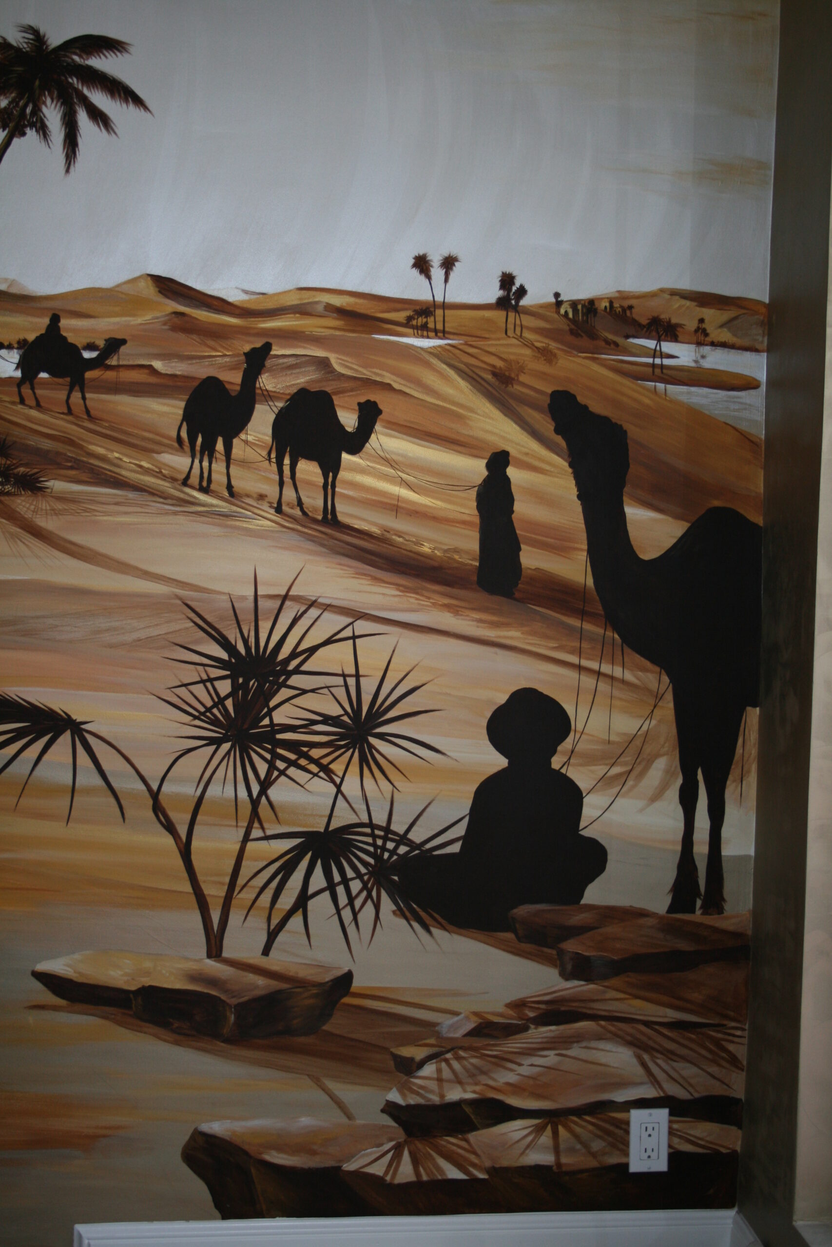 A painting of people and camels in the desert.